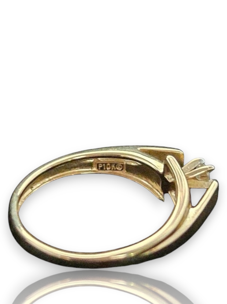 A gold ring with a four-prong setting and a central gemstone, shown from the back to reveal a 'FIDIO' hallmark. 