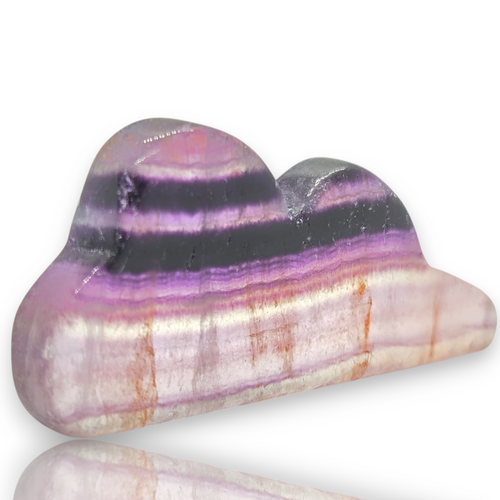 A polished purple and black banded stone sculpture with horizontal bands of lavender, dark charcoal, and pale pinkish-white, shown on a white background 
