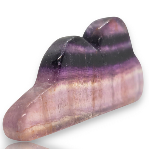 A polished purple and pink striped gemstone cabochon with a glossy finish, displayed on a white background 
