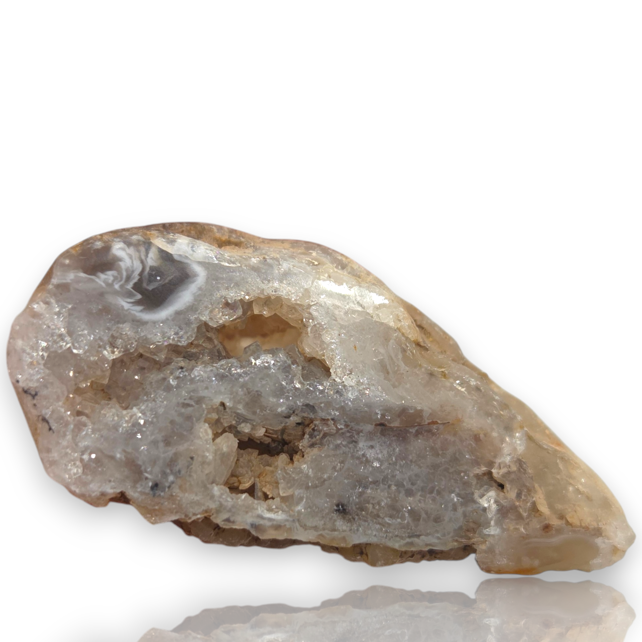 Crystal Chrysalis Haus A raw geode specimen with a natural rough outer layer and a crystalline inner cavity, shown on a white background 