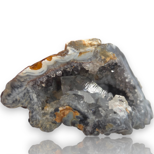 Crystal Chrysalis Haus A geode specimen with clear quartz crystal points and brown, white, and gray agate layers, displayed on a white background 