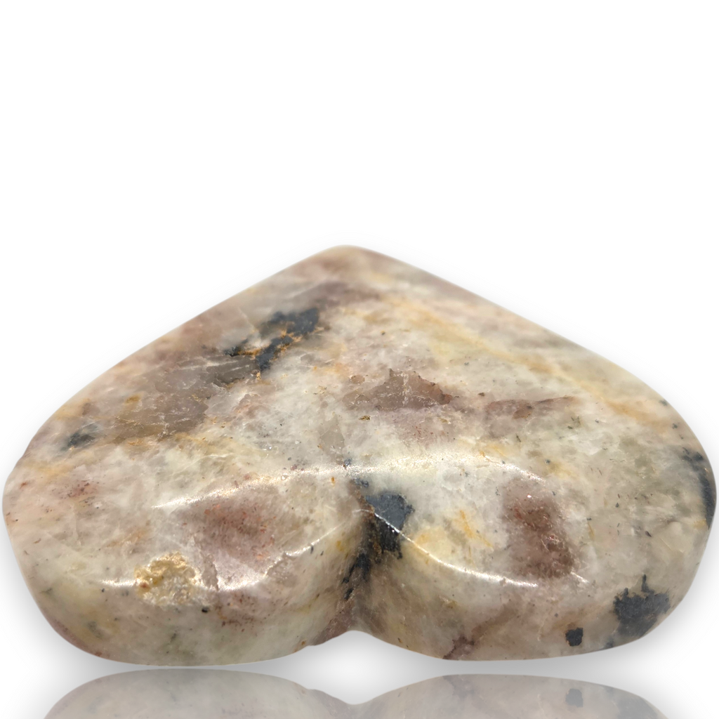Crystal Chrysalis Haus  A polished heart-shaped stone with a marbled pattern of beige, brown, gray, and black, displayed on a white background with a reflection below 