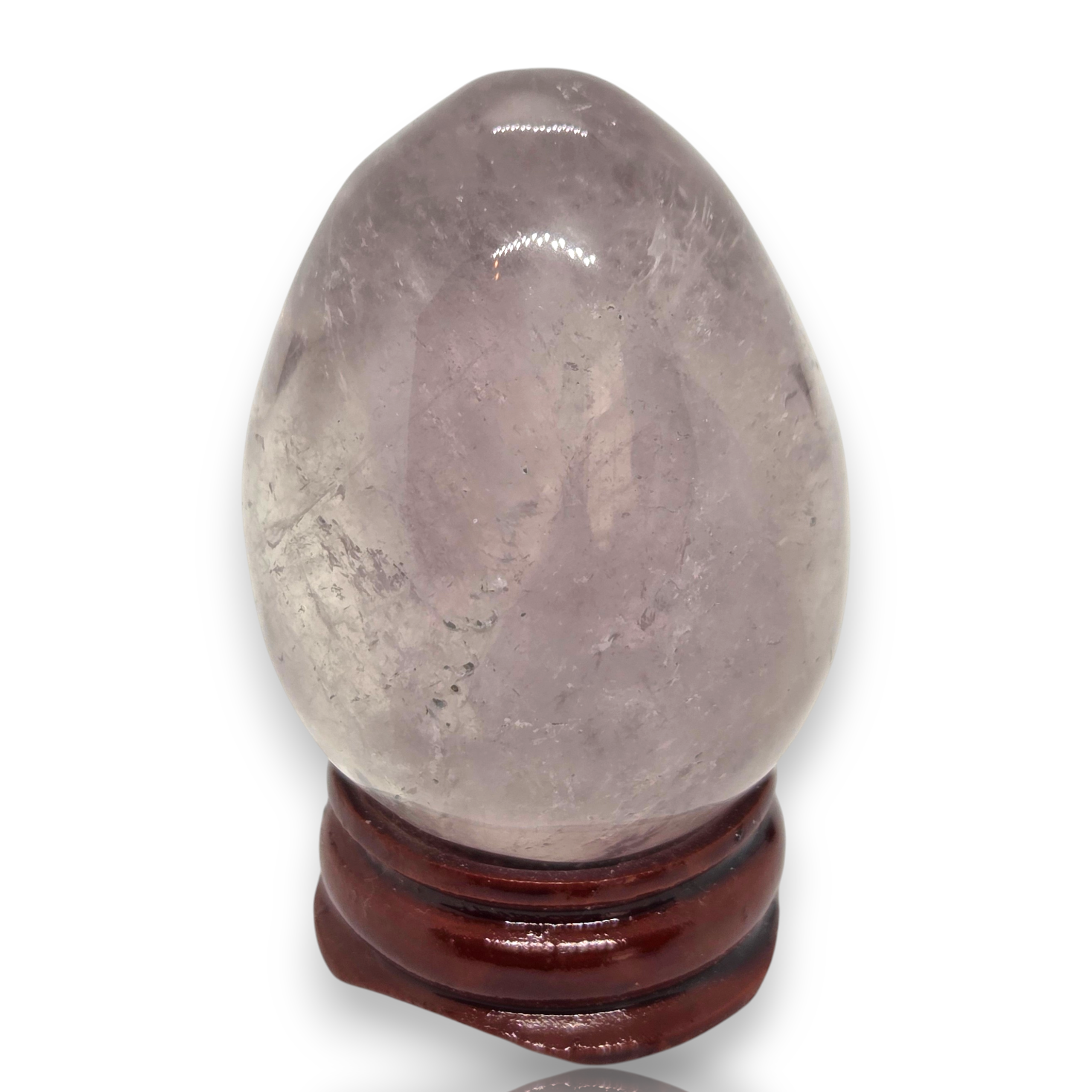 Crystal Chrysalis Haus A polished oval crystal sphere in pale lavender-gray tones displayed on a dark reddish-brown wooden stand against a white background