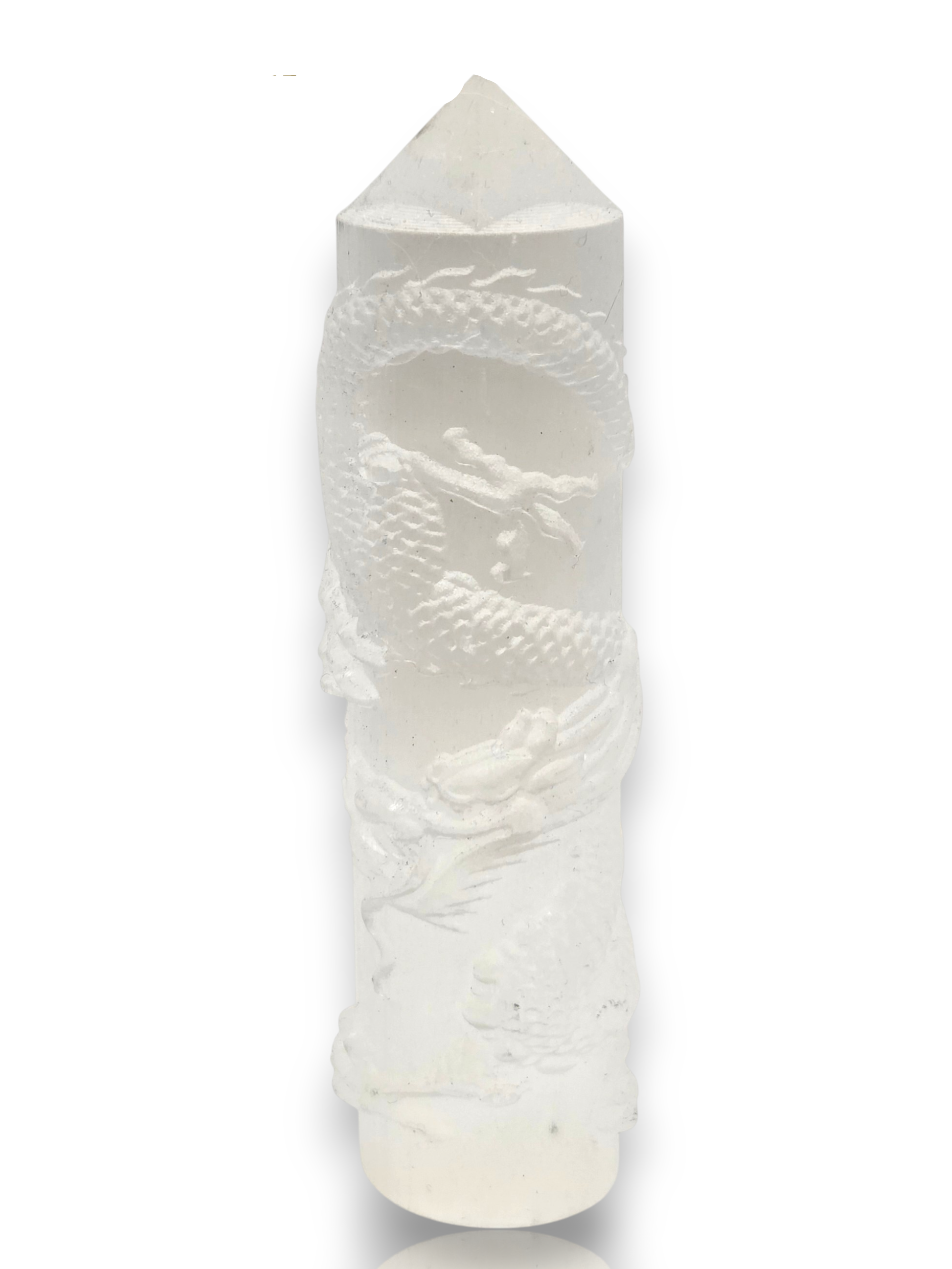 Crystal Chrysalis Haus A white carved crystal point tower featuring a detailed dragon design wrapped around its cylindrical body, with a conical top and rounded base