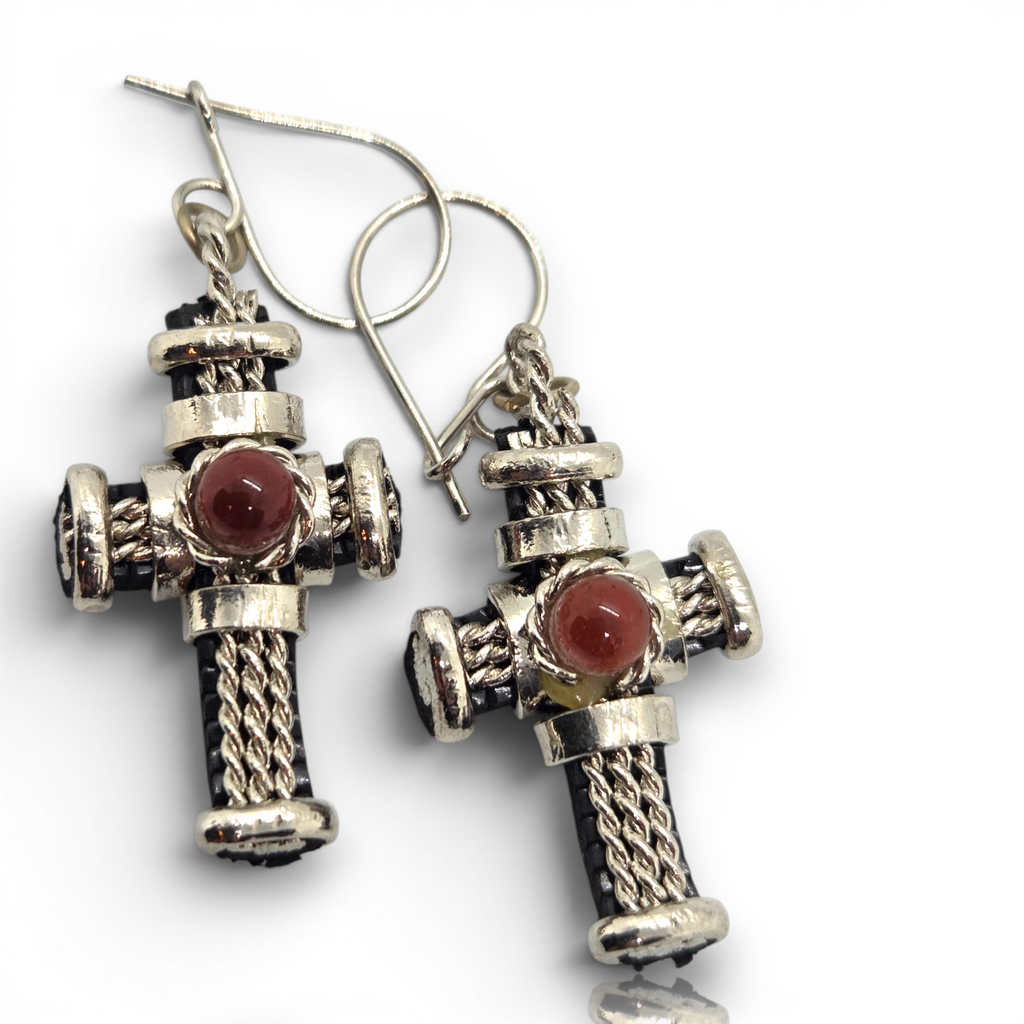 Crystal Chrysalis Haus A pair of silver-toned cross dangle earrings with twisted rope details and round reddish-brown stone centers, shown on a white background 