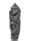 Crystal Chrysalis Haus A dark gray, dragon-carved cylindrical object with a pointed top, shown on a plain white background 