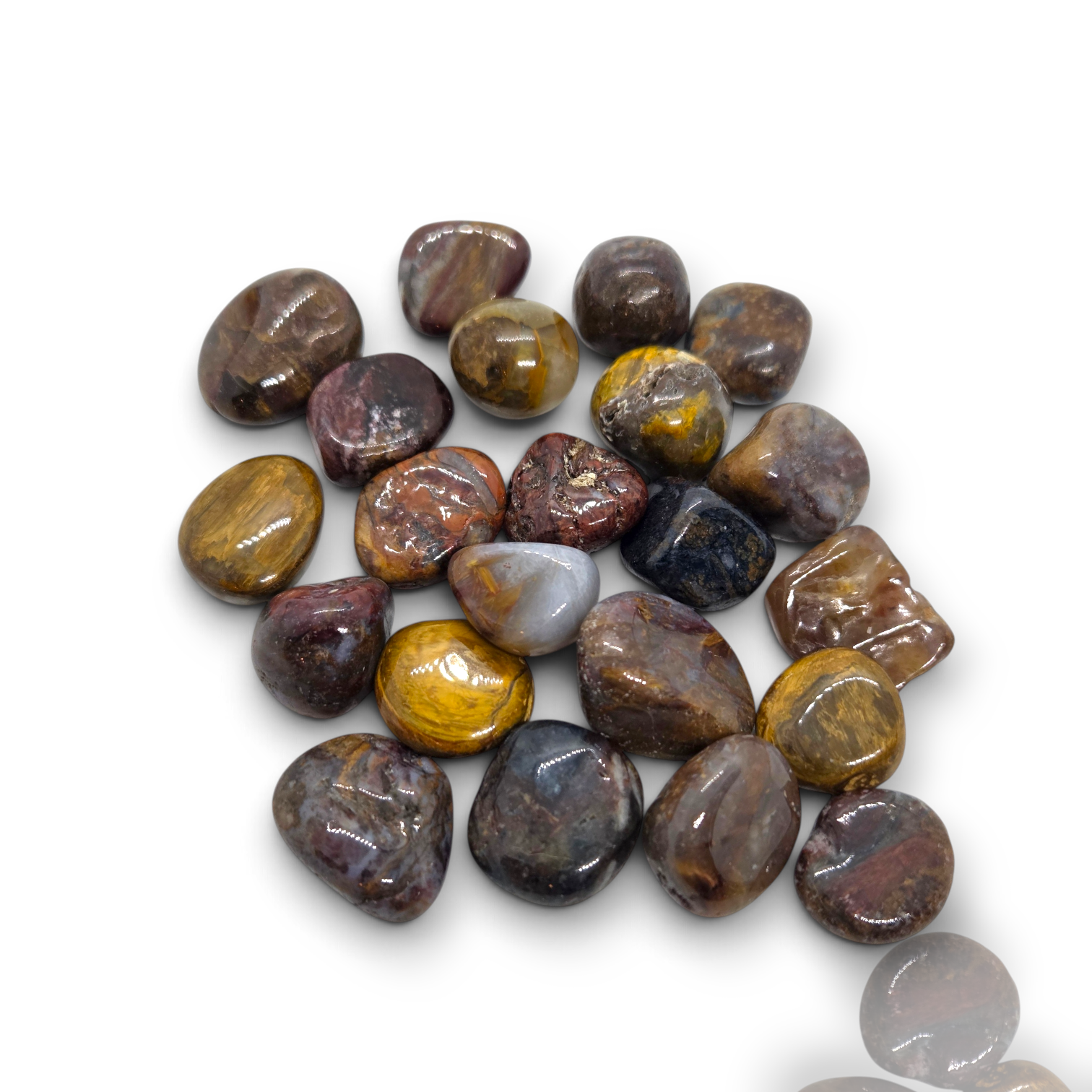 Crystal Chrysalis Haus A pile of polished tumbled gemstone chips in earthy brown, gold, gray, and purple tones, arranged on a plain white background.