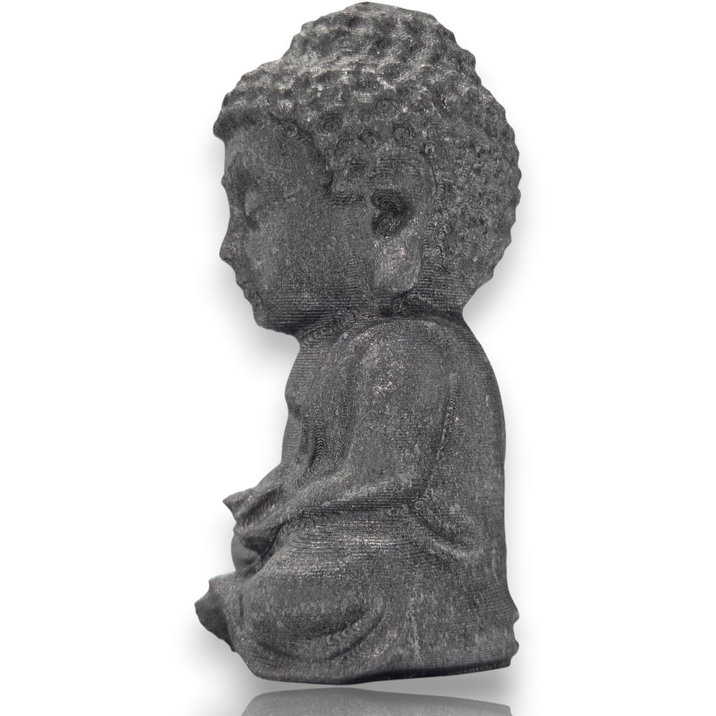 Crystal Chrysalis Haus A small gray stone Buddha statue shown in profile, seated with hands folded, on a clean white background with a soft reflection below.