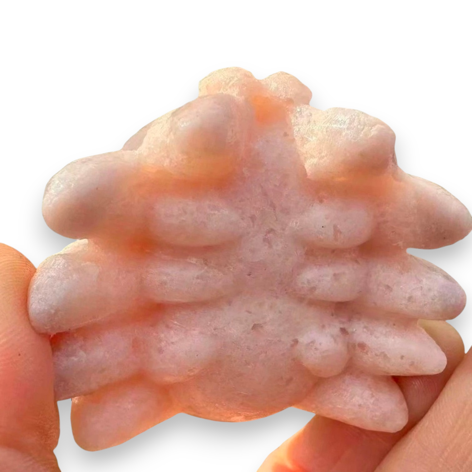 A pale pink textured cat scratcher held between two human hands against a white background