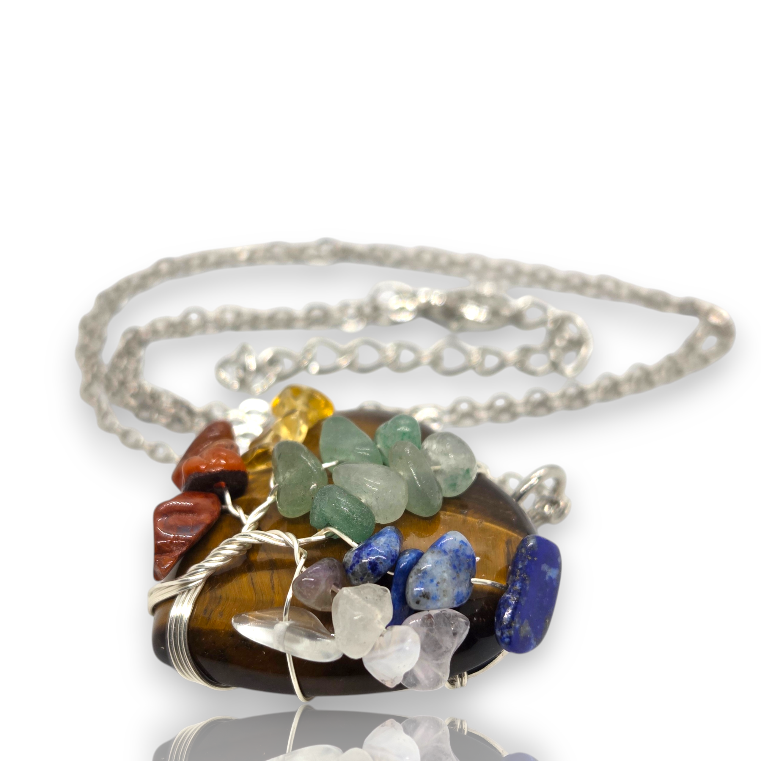 Crystal Chrysalis Haus A silver wire-wrapped necklace featuring a polished brown tiger's eye stone pendant adorned with various colorful tumbled stones including green, blue, purple, red, yellow, and white, shown on a white background with a soft reflection.