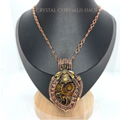 A copper-toned necklace with a detailed mechanical pendant featuring a bee and spiral gears, displayed on a black jewelry bust.