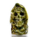 A carved green stone skull sculpture with a hooded, ghostly appearance, shown on a plain white background 