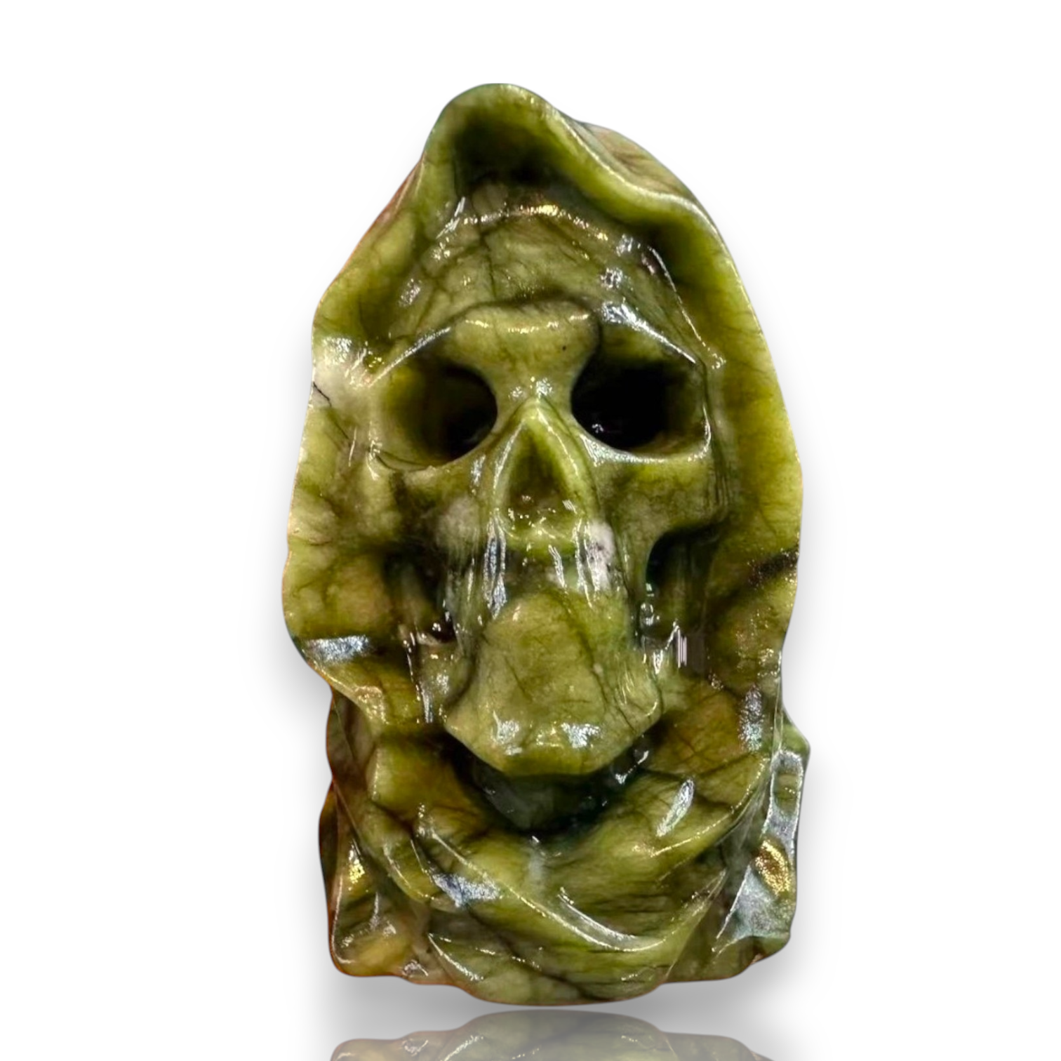 A carved green stone skull sculpture with a hooded, ghostly appearance, shown on a plain white background 