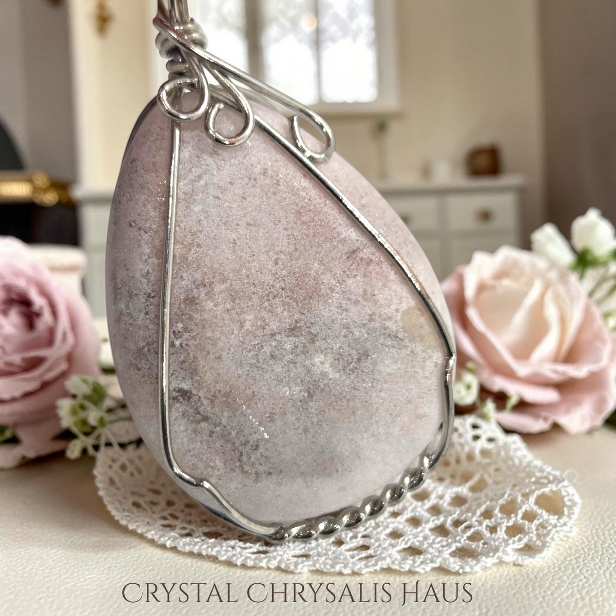 Crystal Chrysalis Haus handcrafted silver wire wrapped natural pink opal pear cut pendant on a lace doily with roses